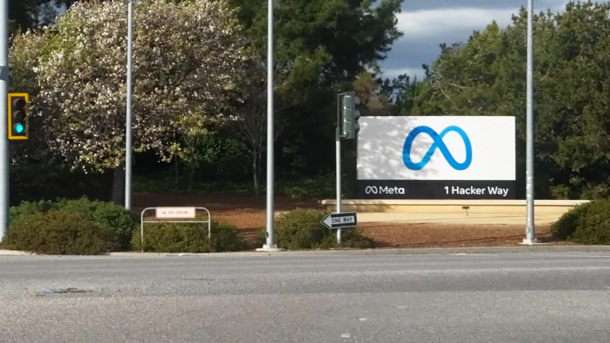 Insegna all'ingresso della sede Meta a Menlo Park con il logo e l'indirizzo 1 Hacker Way