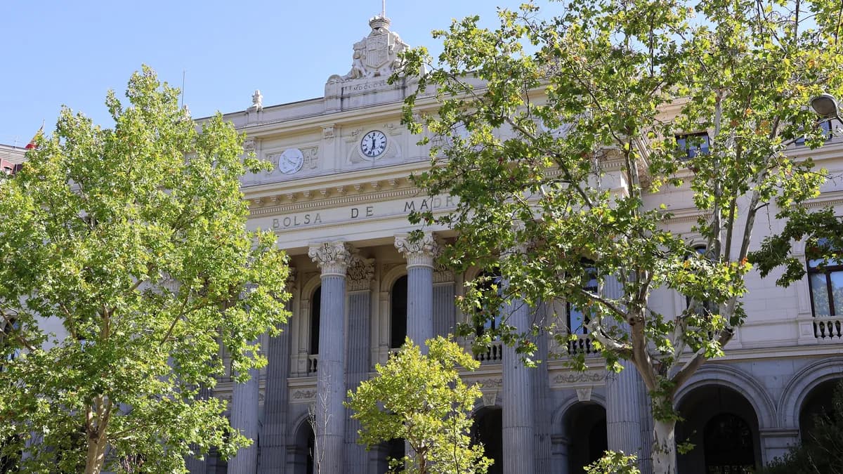 The "BOLSA DE MADRID" lettering and two clocks on the palace's façade, seen through the trees (illustrative image)