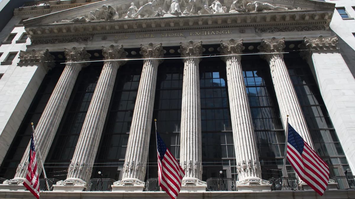 La facciata con colonne del New York Stock Exchange, con tre bandiere americane davanti (immagine illustrativa)