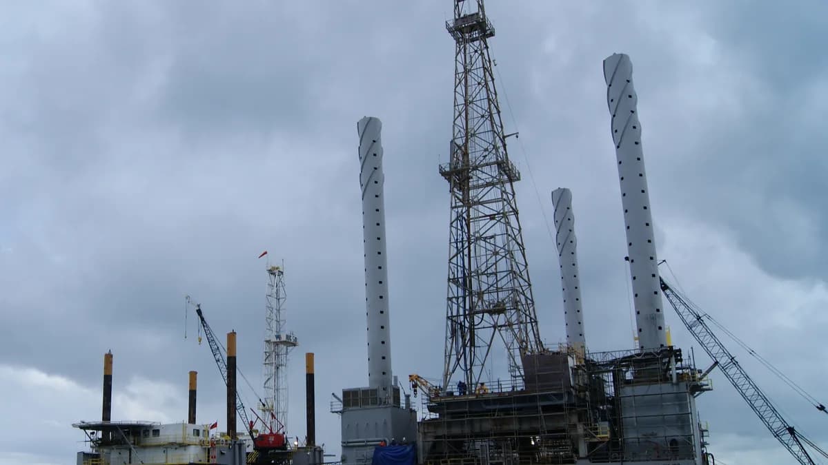 An offshore oil rig docked at a pier off Trinidad, with its drilling tower and jack-up legs (illustrative image)